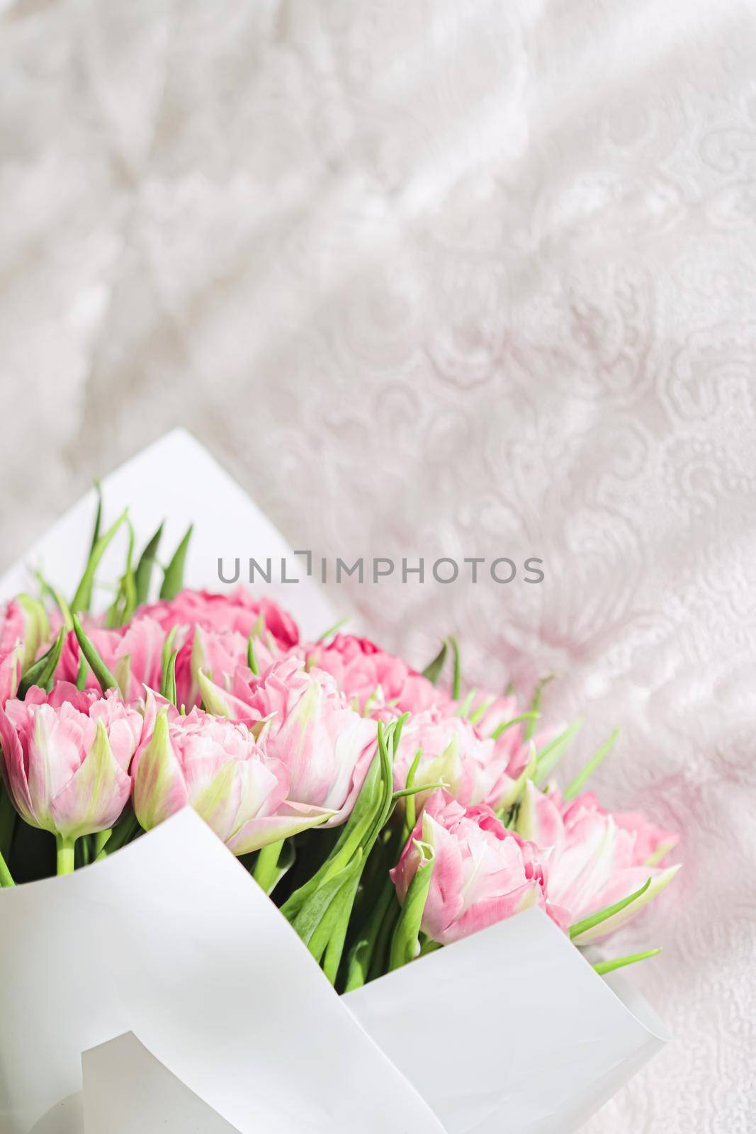 Romantic bouquet of pink tulips on bed in bedroom, holiday gift by Anneleven