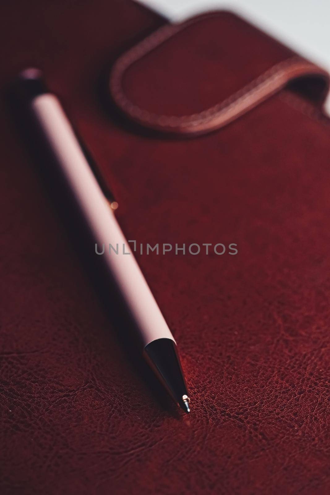Pen and leather briefcase in office, closeup