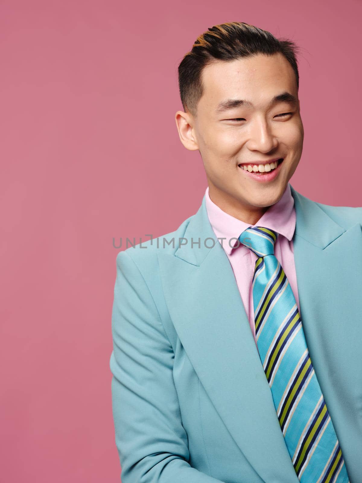 man of Asian appearance blue suit self confidence pink background by SHOTPRIME