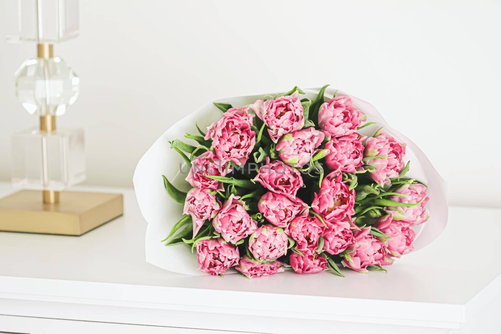 Bouquet of fresh cut pink tulips in an elegant interior, home decor closeup