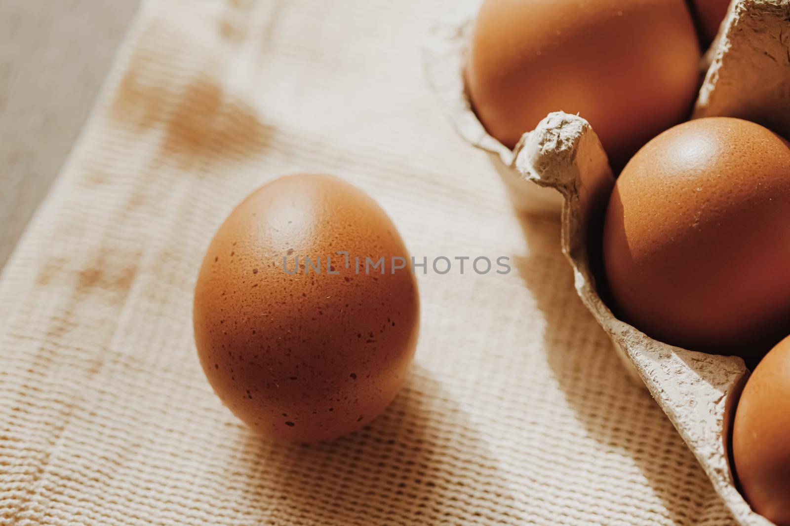 organic farm eggs in egg box and rustic cloth napkins, closeup