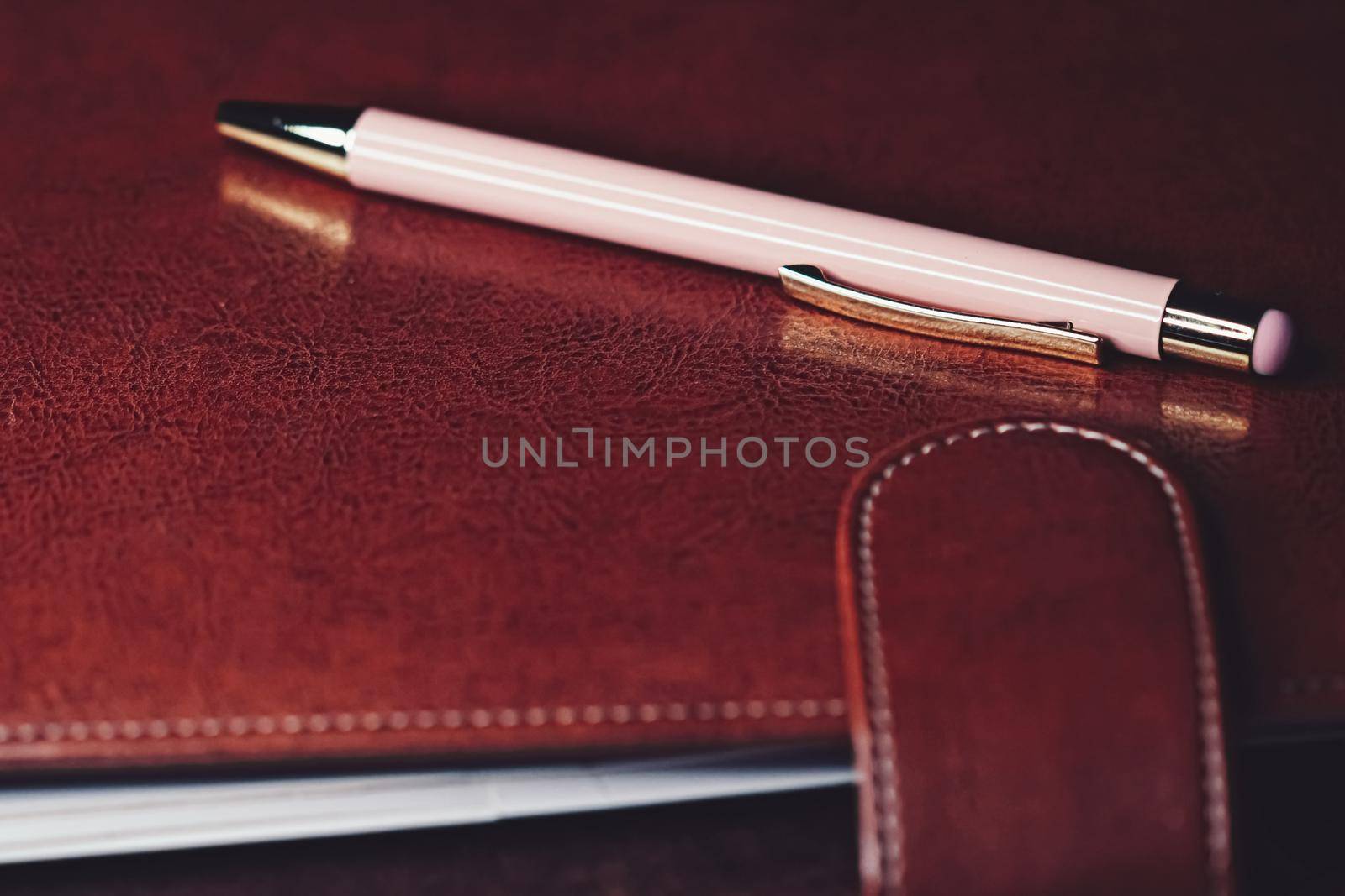 Pen and leather briefcase in office, closeup