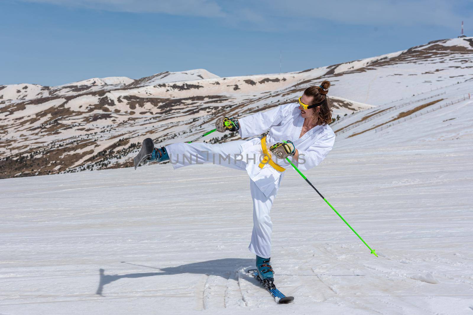 Skier dressed as a karateka at a ski station by martinscphoto