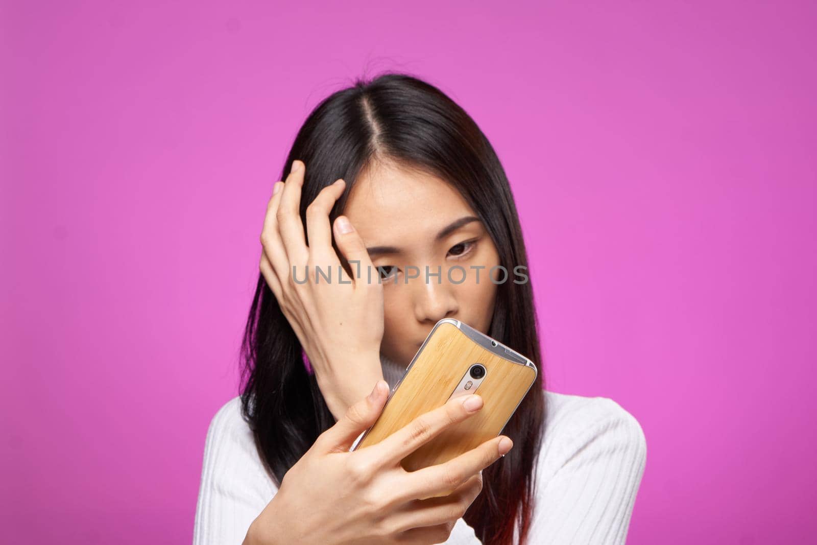 pretty woman with phone in hand internet technology messages pink background. High quality photo
