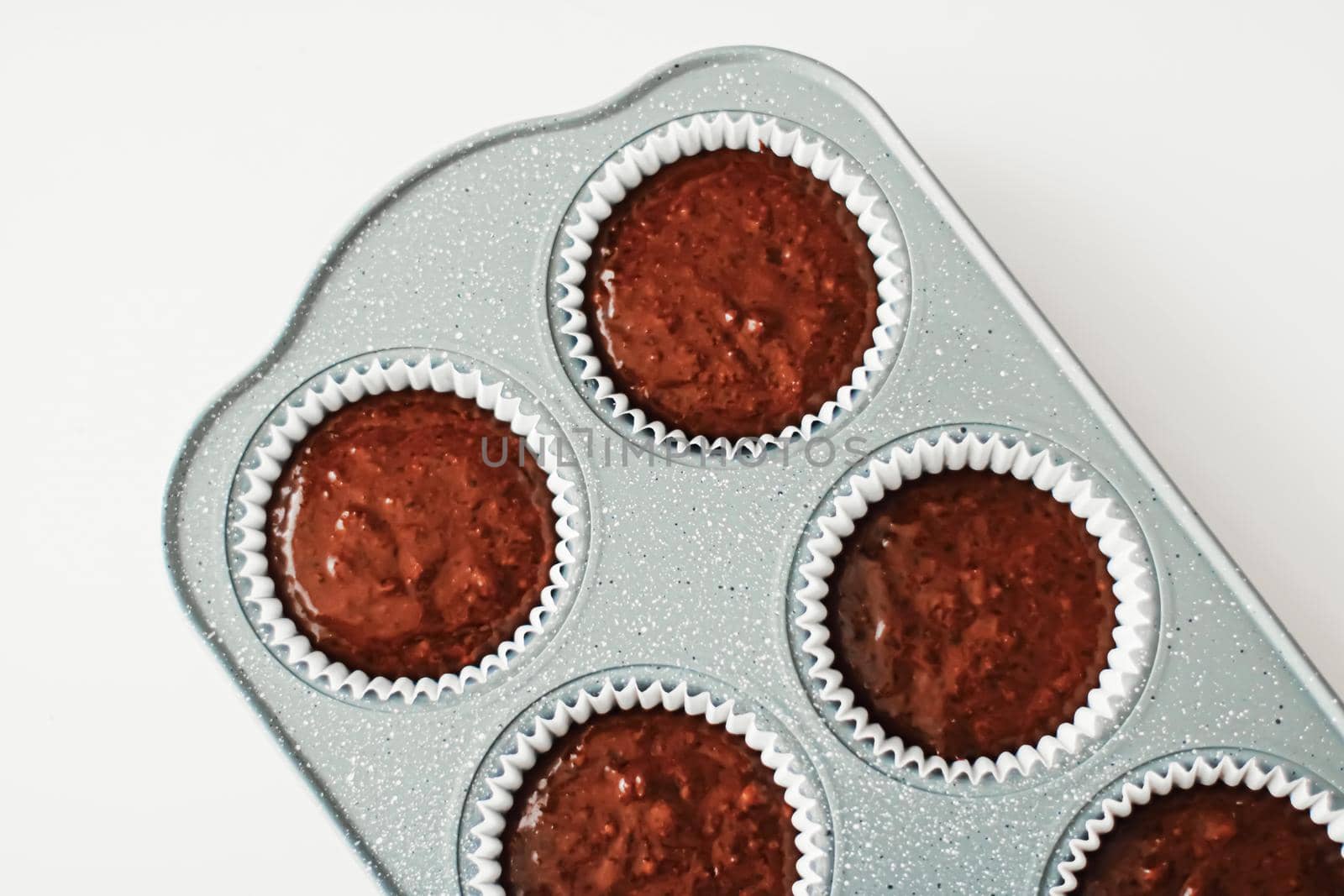 Chocolate muffin or cupcake batter in a pan ready to bake, homemade comfort food recipe concept