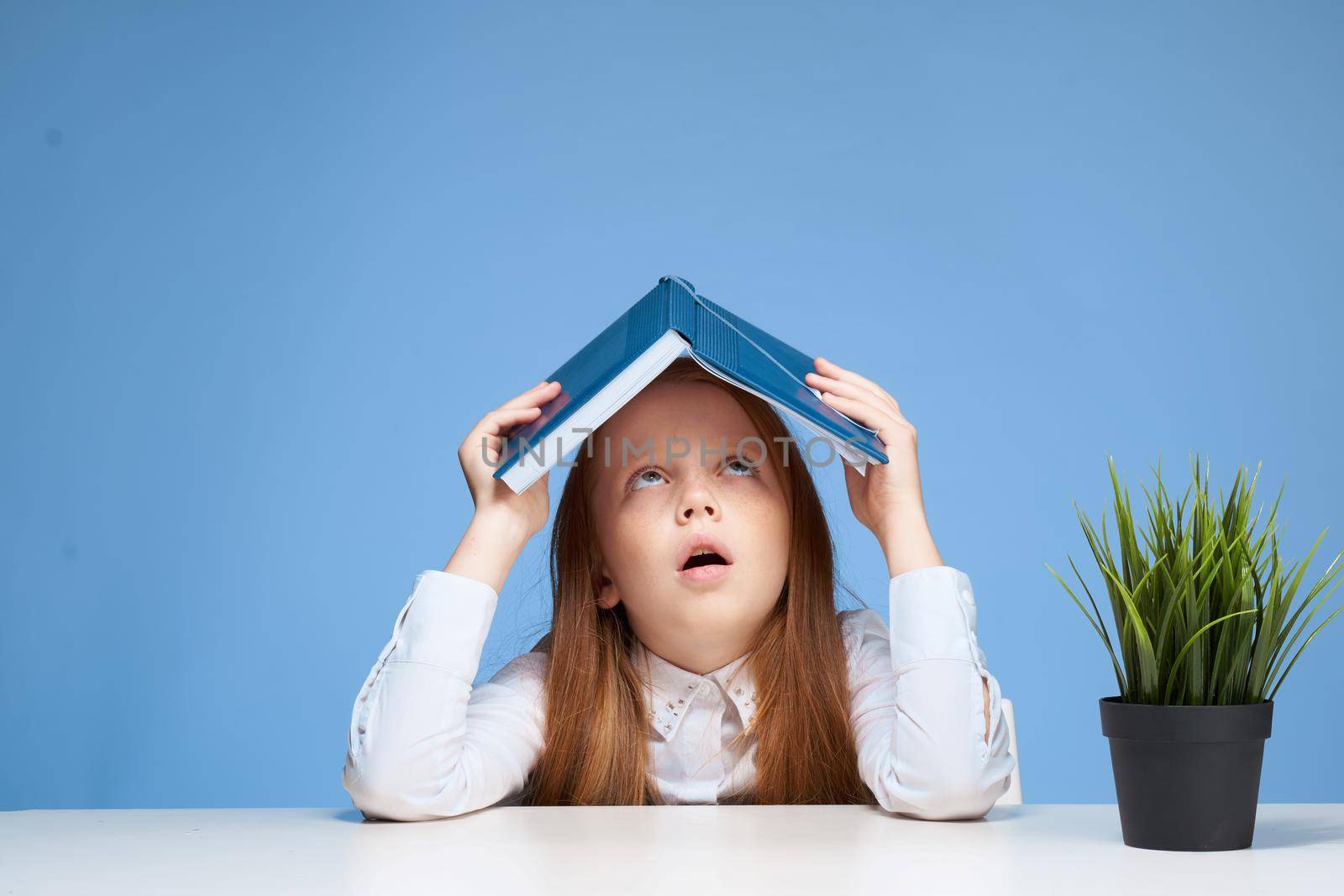 schoolgirl with a book on her head learning lessons lifestyle by SHOTPRIME