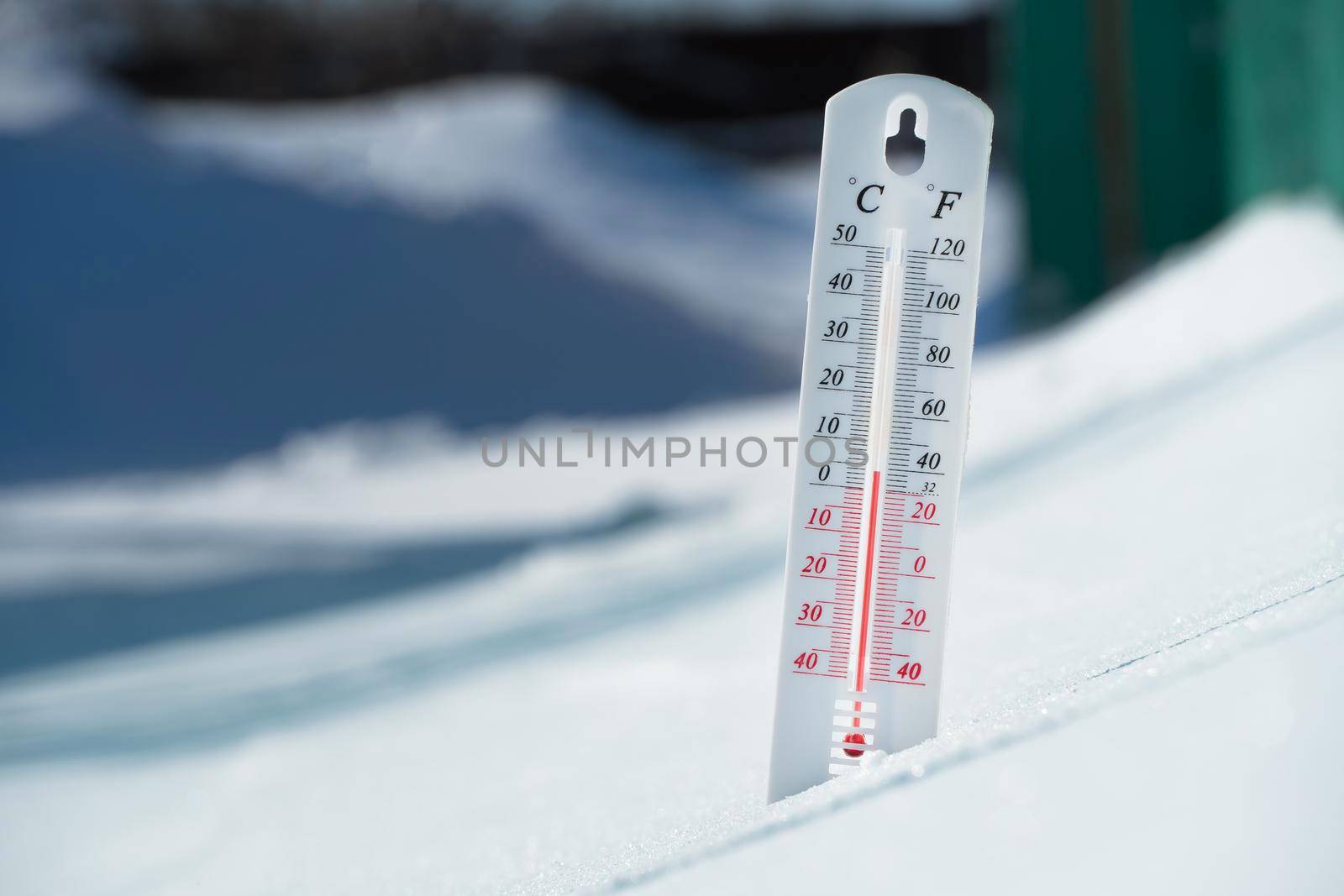 In winter or spring the thermometer lies on the snow and shows a negative temperature in cold weather.Meteorological conditions with low air and ambient temperatures.Climate change and global warming by YevgeniySam