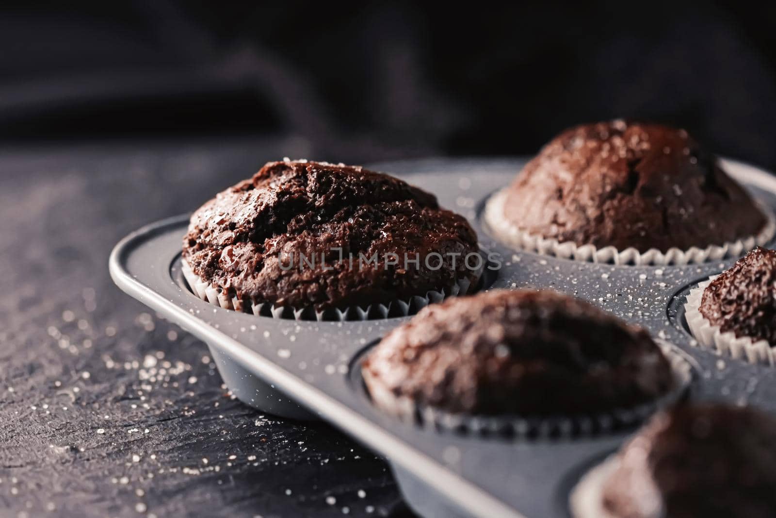 Just baked chocolate muffins in tray, homemade comfort food recipe concept