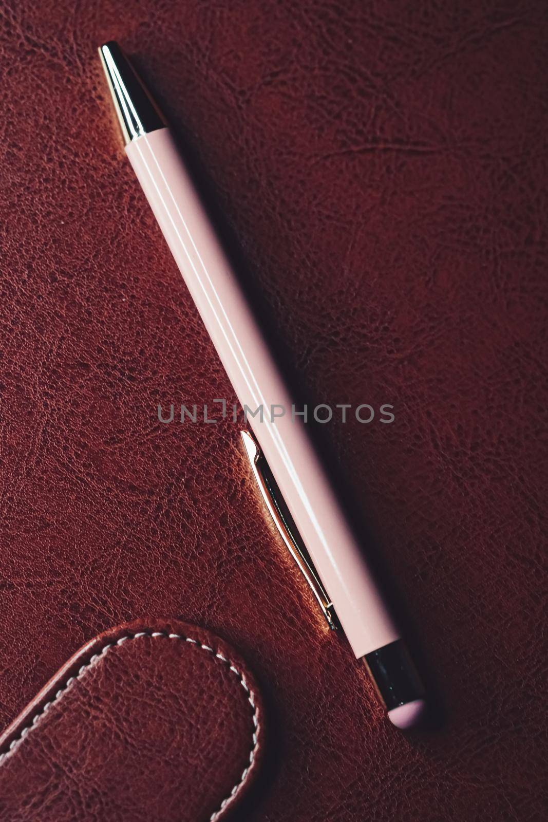 Pen and leather briefcase in office, closeup