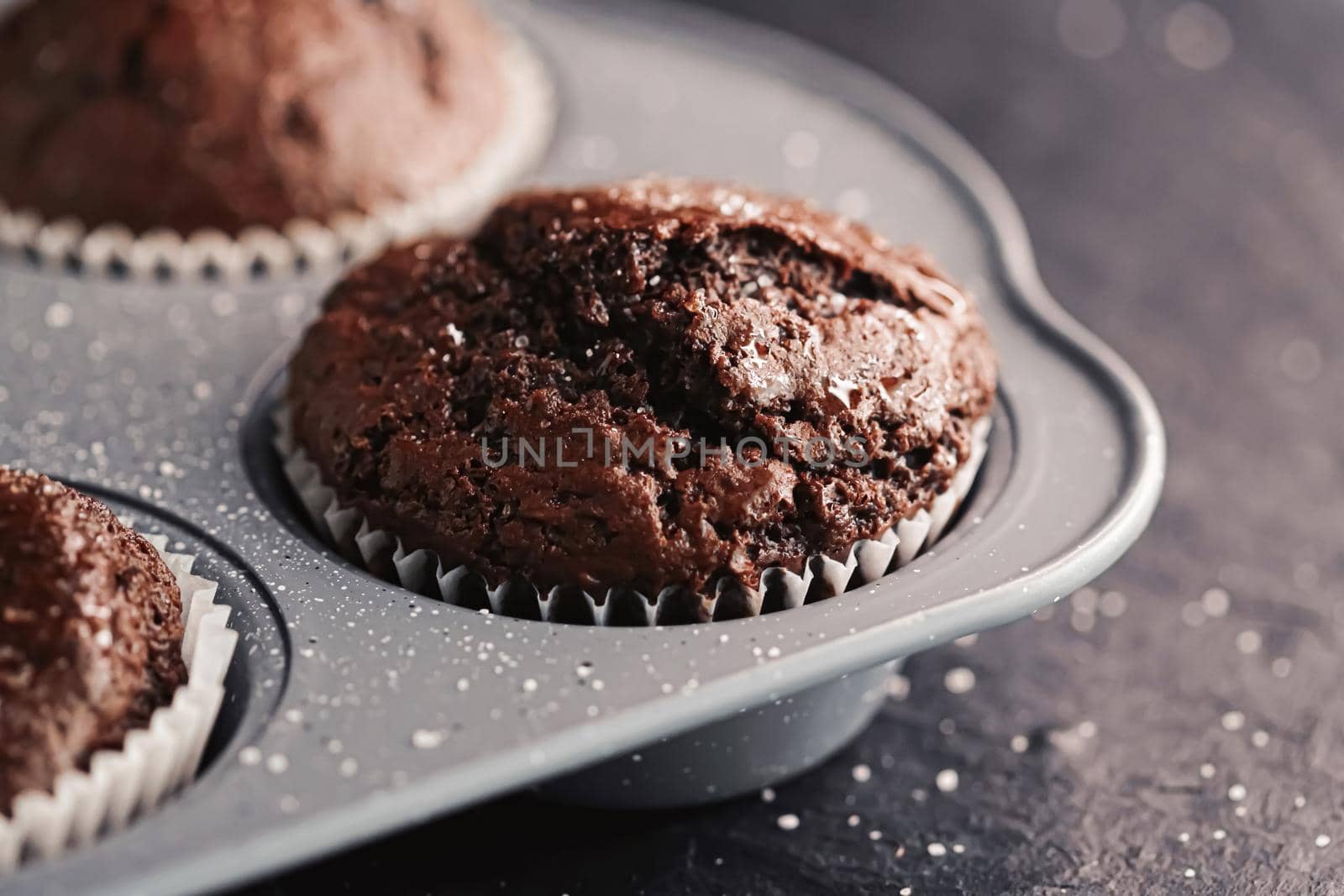 Just baked chocolate muffins in tray, homemade comfort food recipe by Anneleven