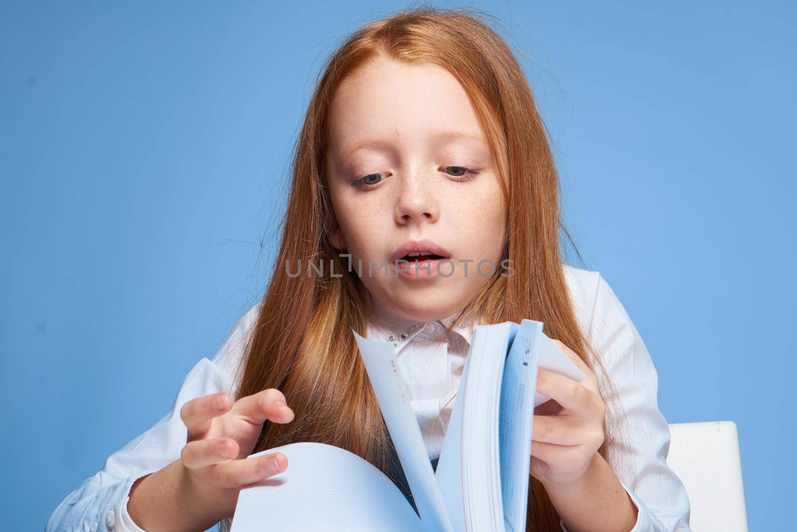 red-haired girl doing homework at home education learning. High quality photo