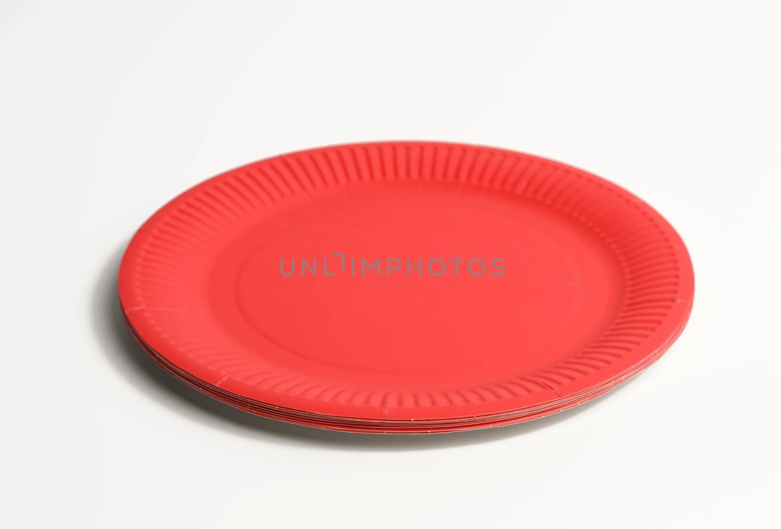 empty red paper disposable plates on a white background, top view. The concept of rejection of plastic by ndanko