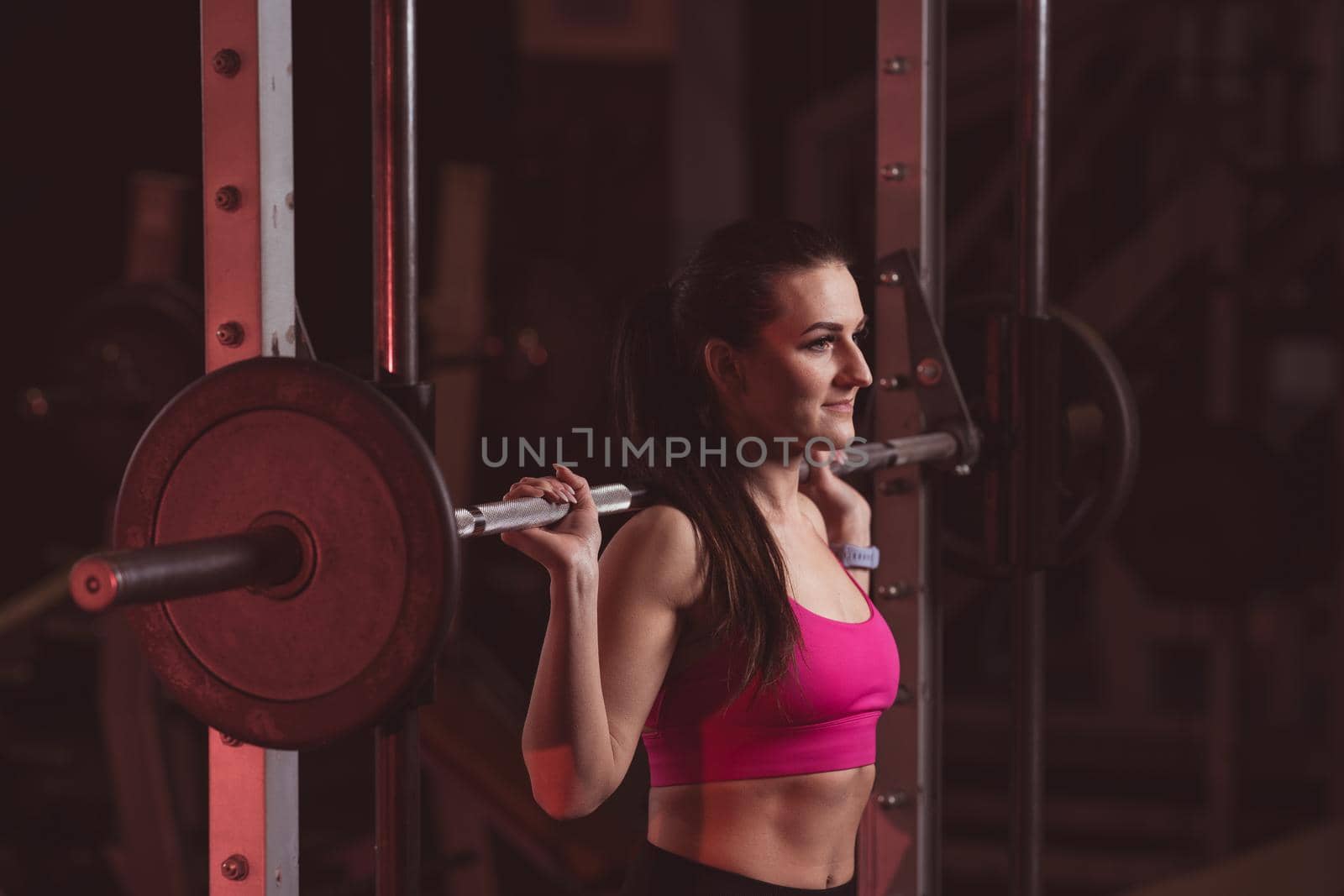 young fitness girl lifts weights in the gym by Edophoto
