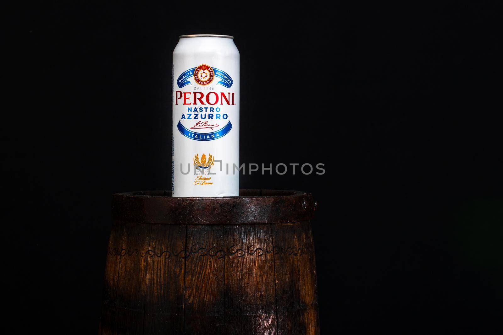 Can of Peroni beer on beer barrel with dark background. Illustrative editorial photo Bucharest, Romania, 2021