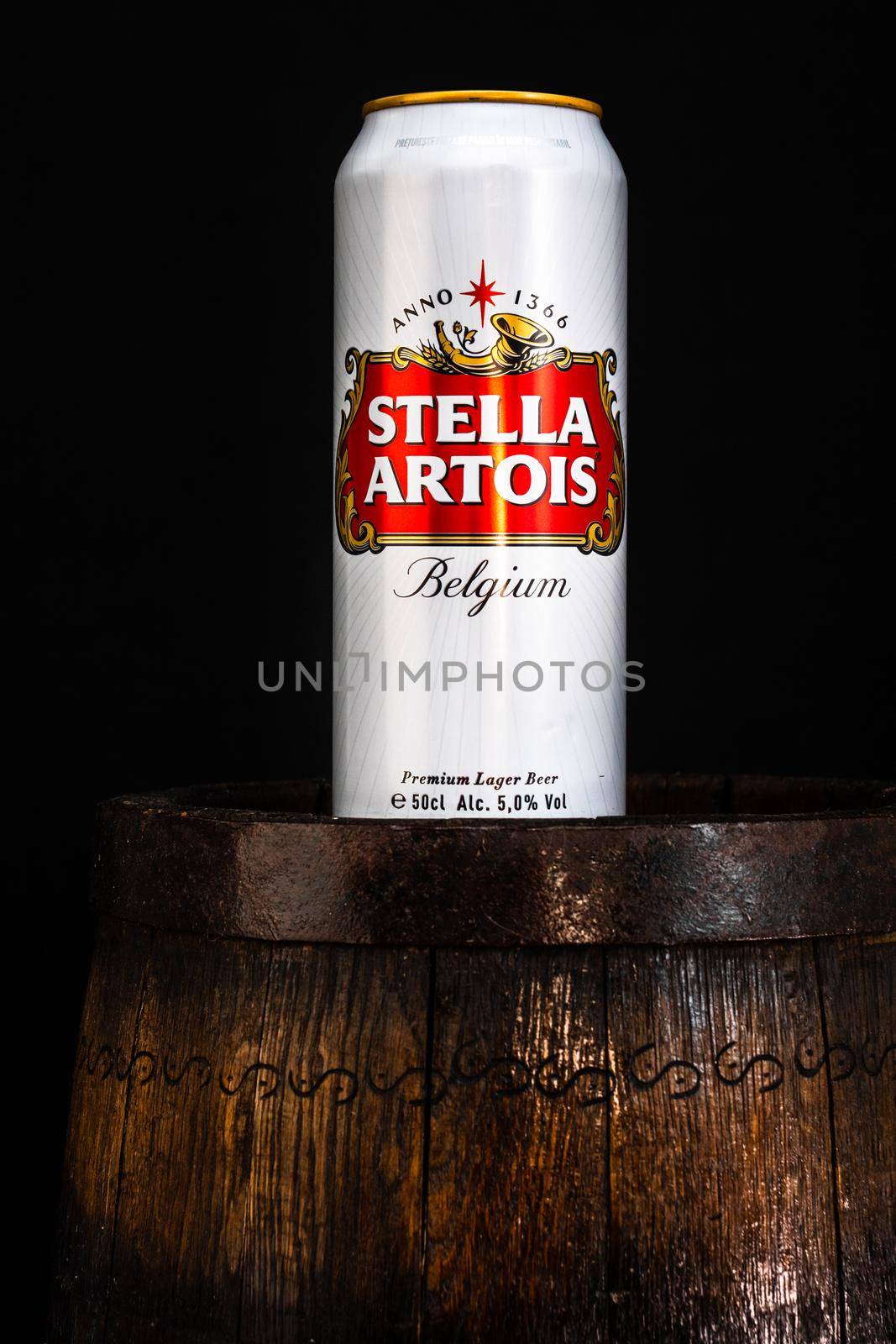 Can of Stella Artois beer on beer barrel with dark background. Illustrative editorial photo Bucharest, Romania, 2021 by vladispas