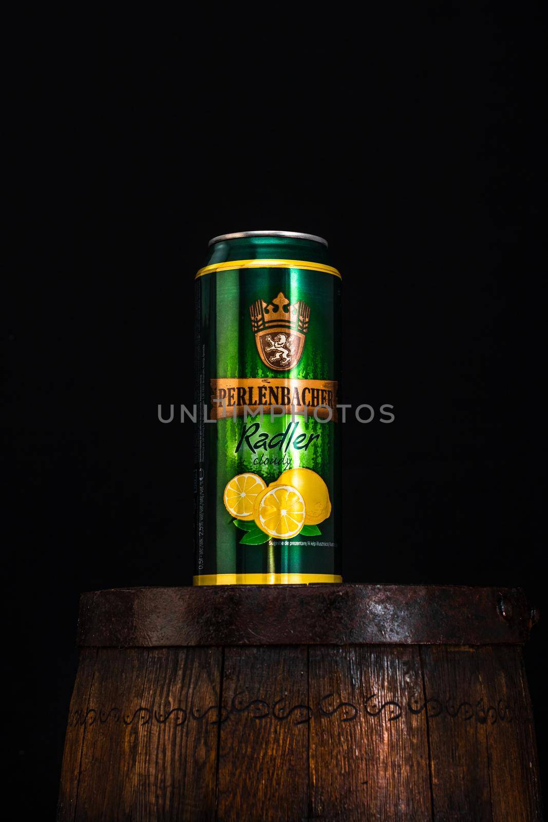 Can of Perlenbacher Radler beer on beer barrel with dark background. Illustrative editorial photo shot in Bucharest, Romania, 2021 by vladispas