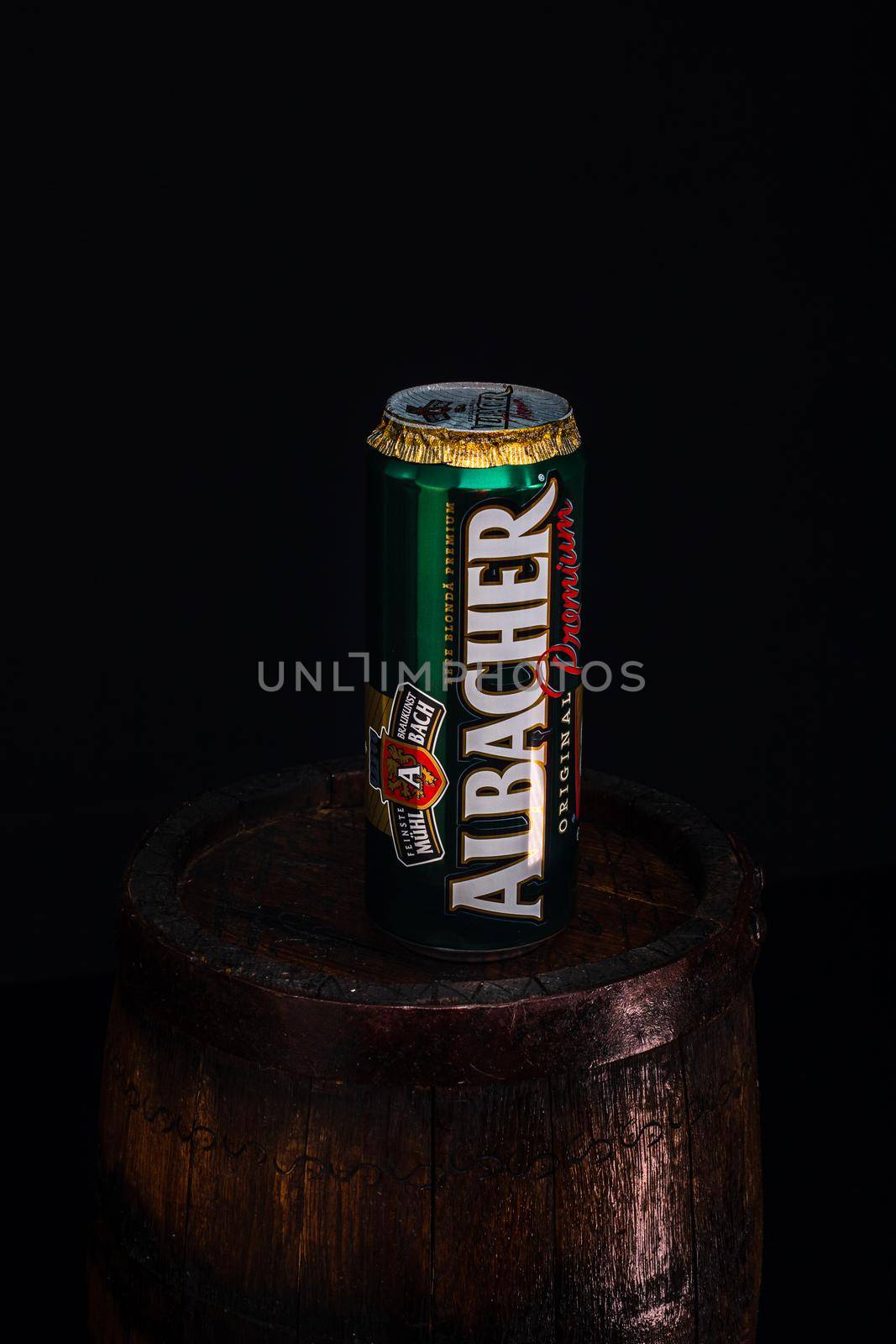 Can of Albacher beer on beer barrel with dark background. Illustrative editorial photo shot in Bucharest, Romania, 2021 by vladispas