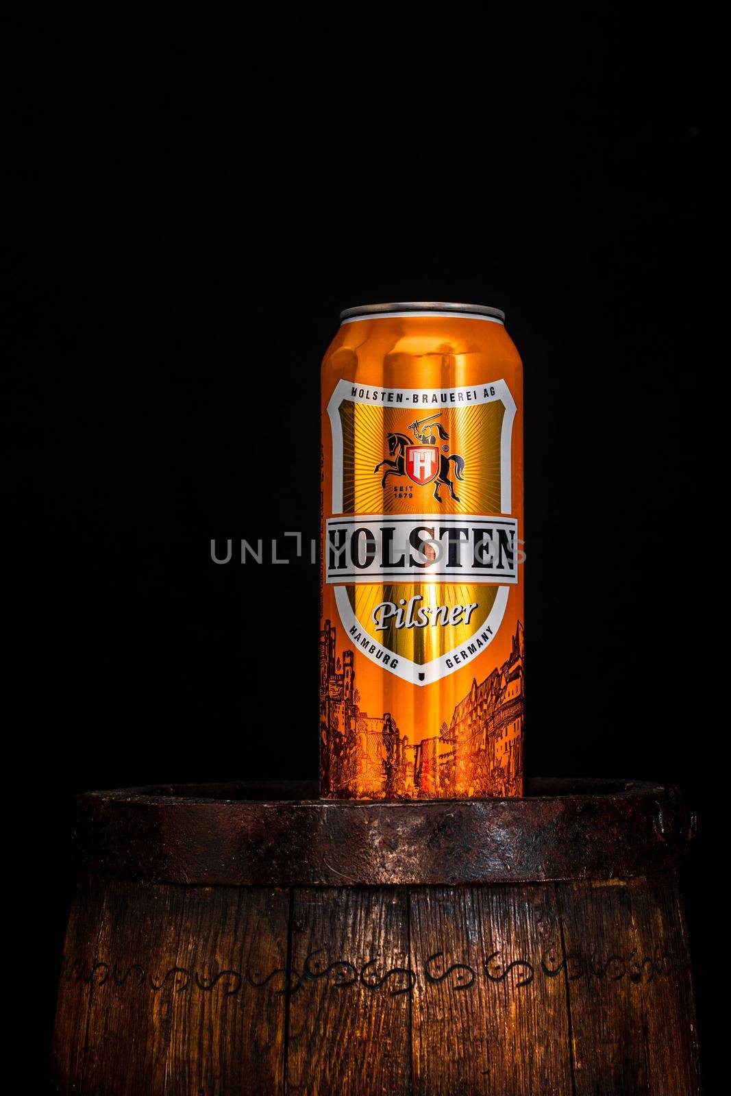 Can of Holsten beer on beer barrel with dark background. Illustrative editorial photo shot in Bucharest, Romania, 2021