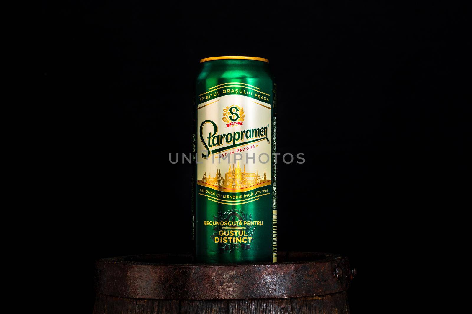 Can of Staropramen beer on beer barrel with dark background. Illustrative editorial photo shot in Bucharest, Romania, 2021