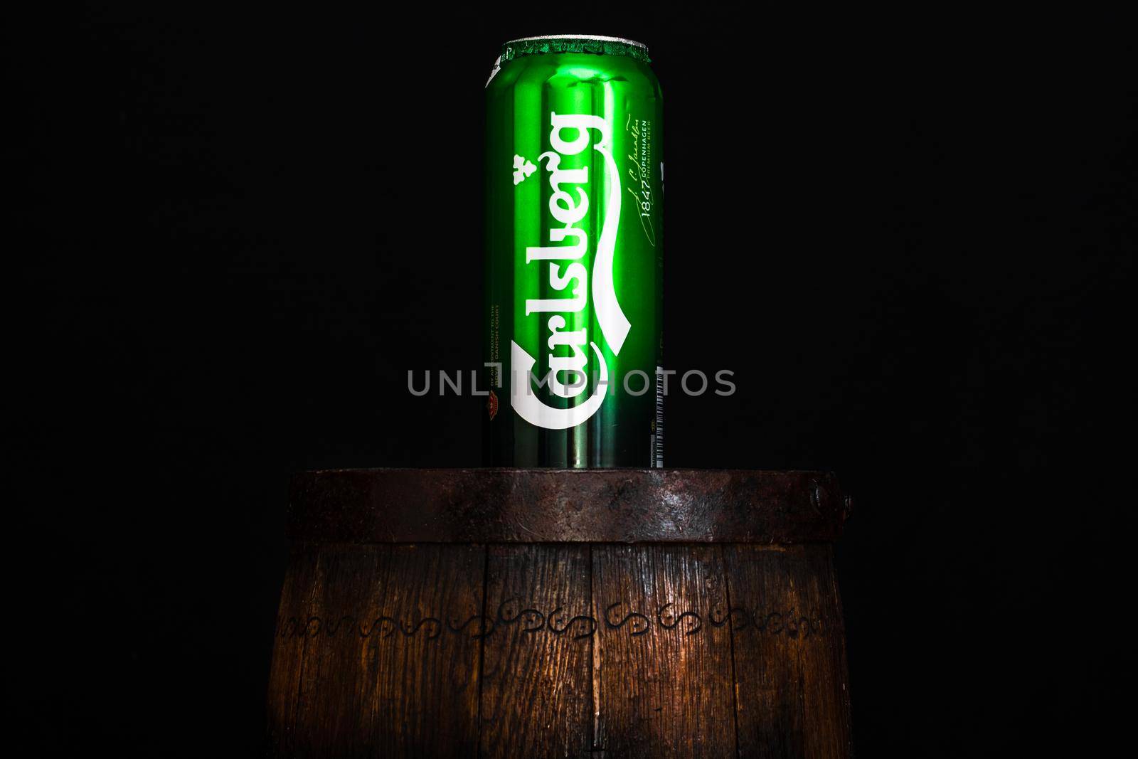 Can of Carsberg beer on beer barrel with dark background. Illustrative editorial photo shot in Bucharest, Romania, 2021 by vladispas