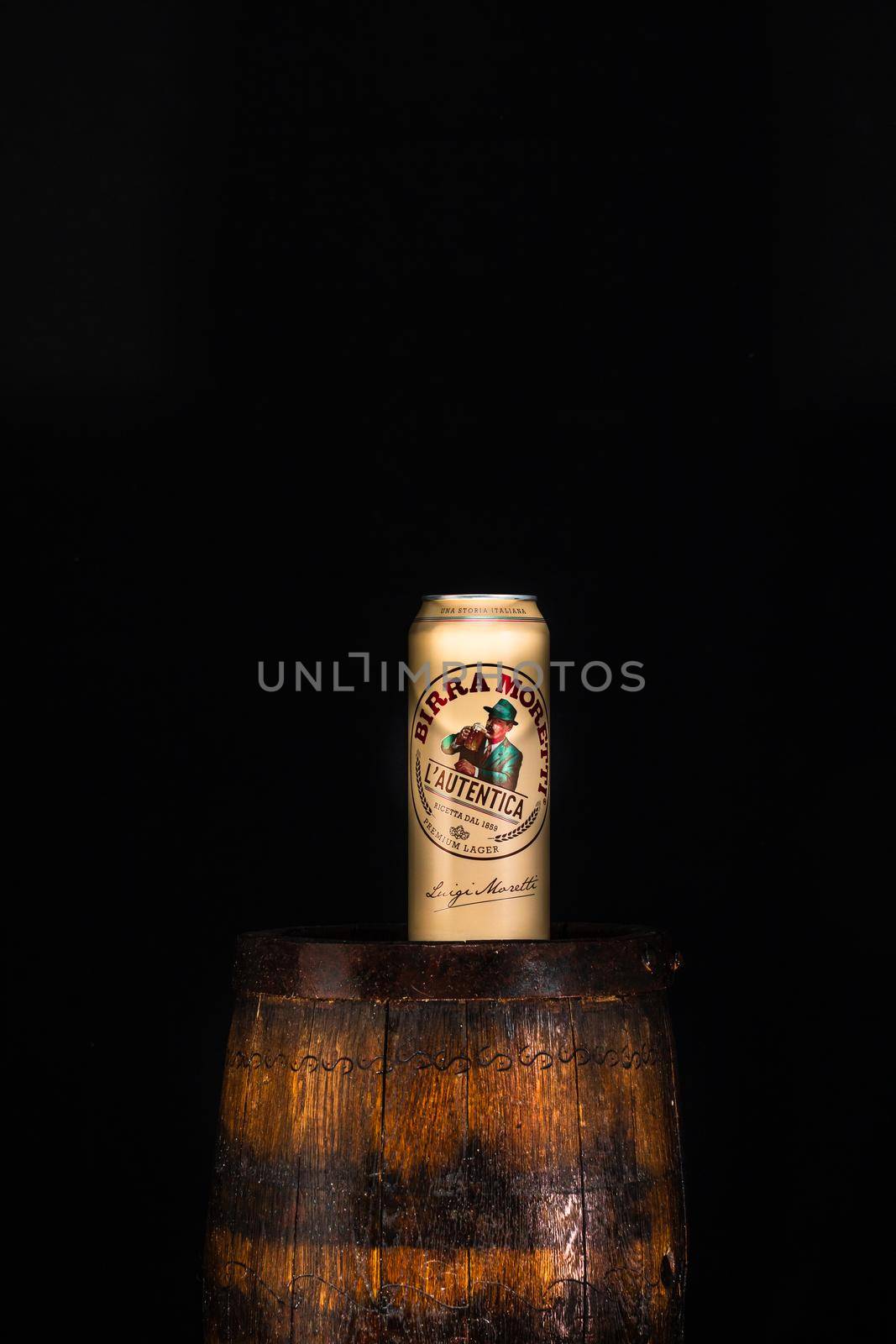 Can of Birra Moretti beer on wooden barrel with dark background. Illustrative editorial photo Bucharest, Romania, 2021