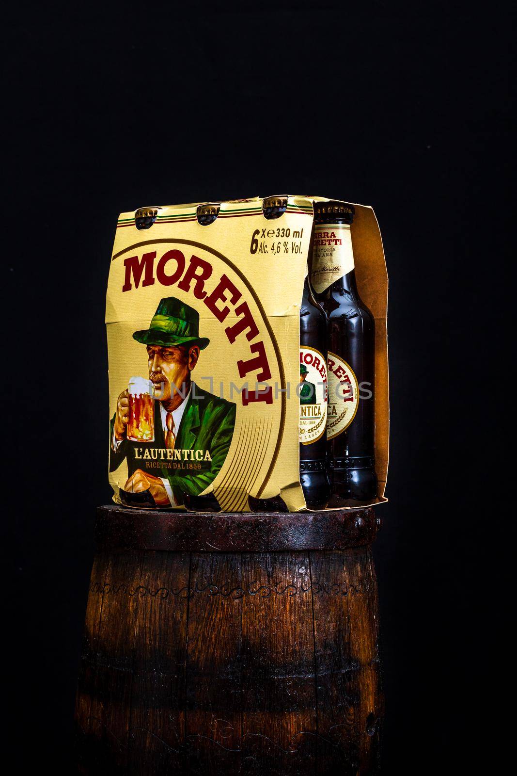 6 pack of Birra Moretti beer on wooden barrel with dark background. Illustrative editorial photo Bucharest, Romania, 2021 by vladispas