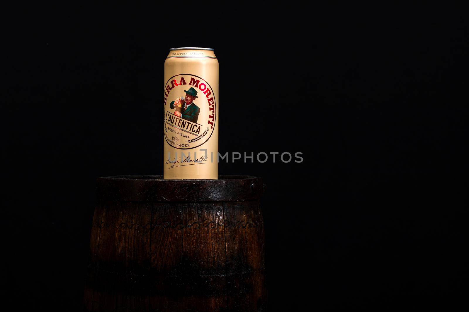 Can of Birra Moretti beer on wooden barrel with dark background. Illustrative editorial photo Bucharest, Romania, 2021