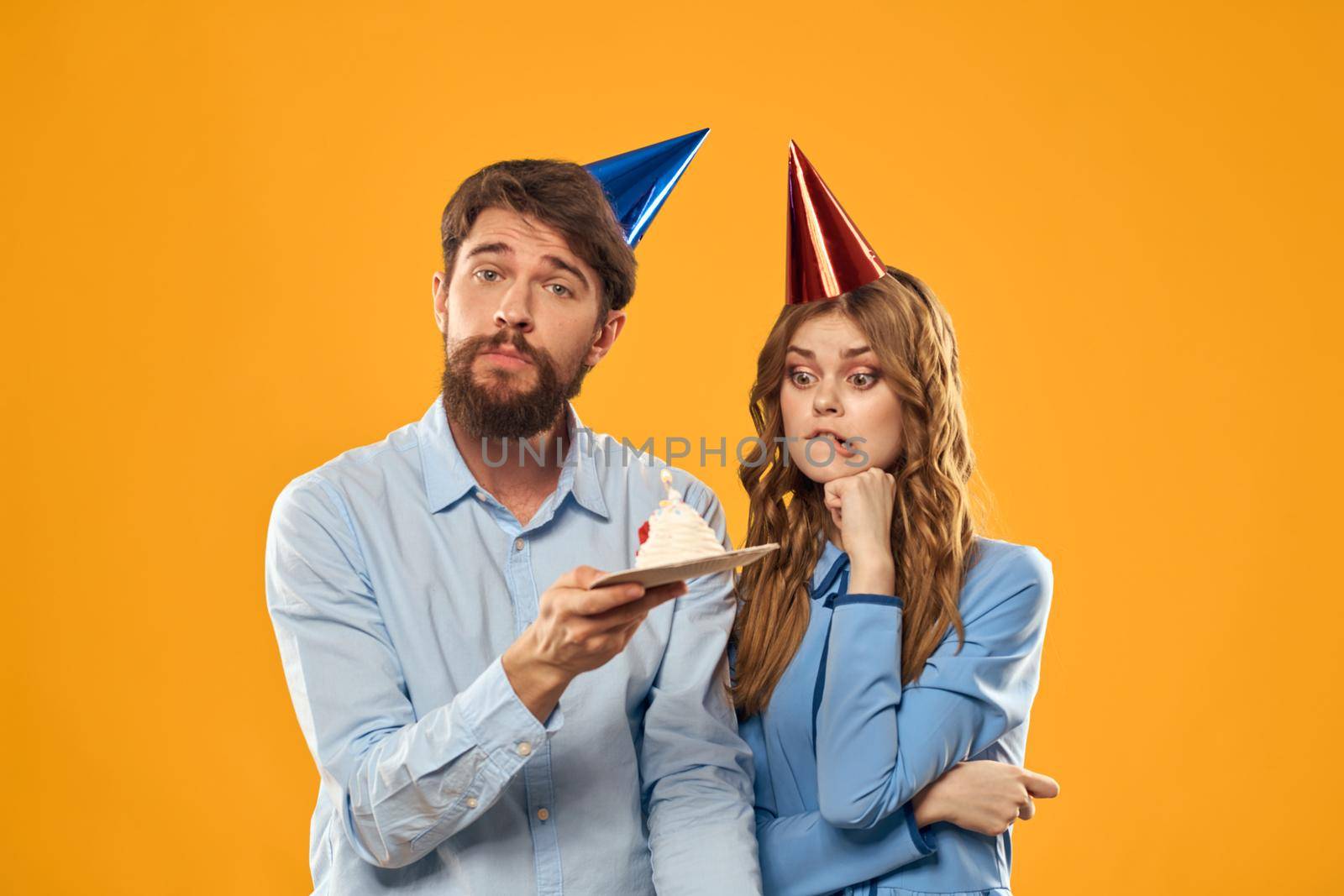 Happy man and woman with birthday cake on yellow background by SHOTPRIME