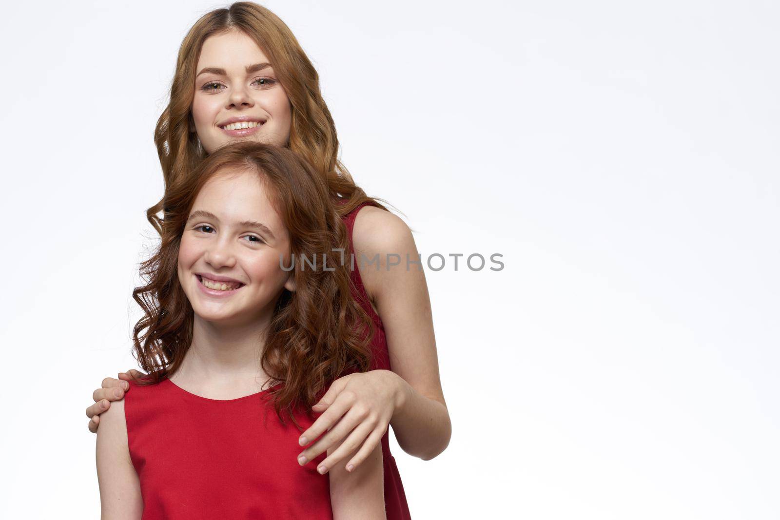 Mom and daughter stand side by side and fun family joy light background. High quality photo