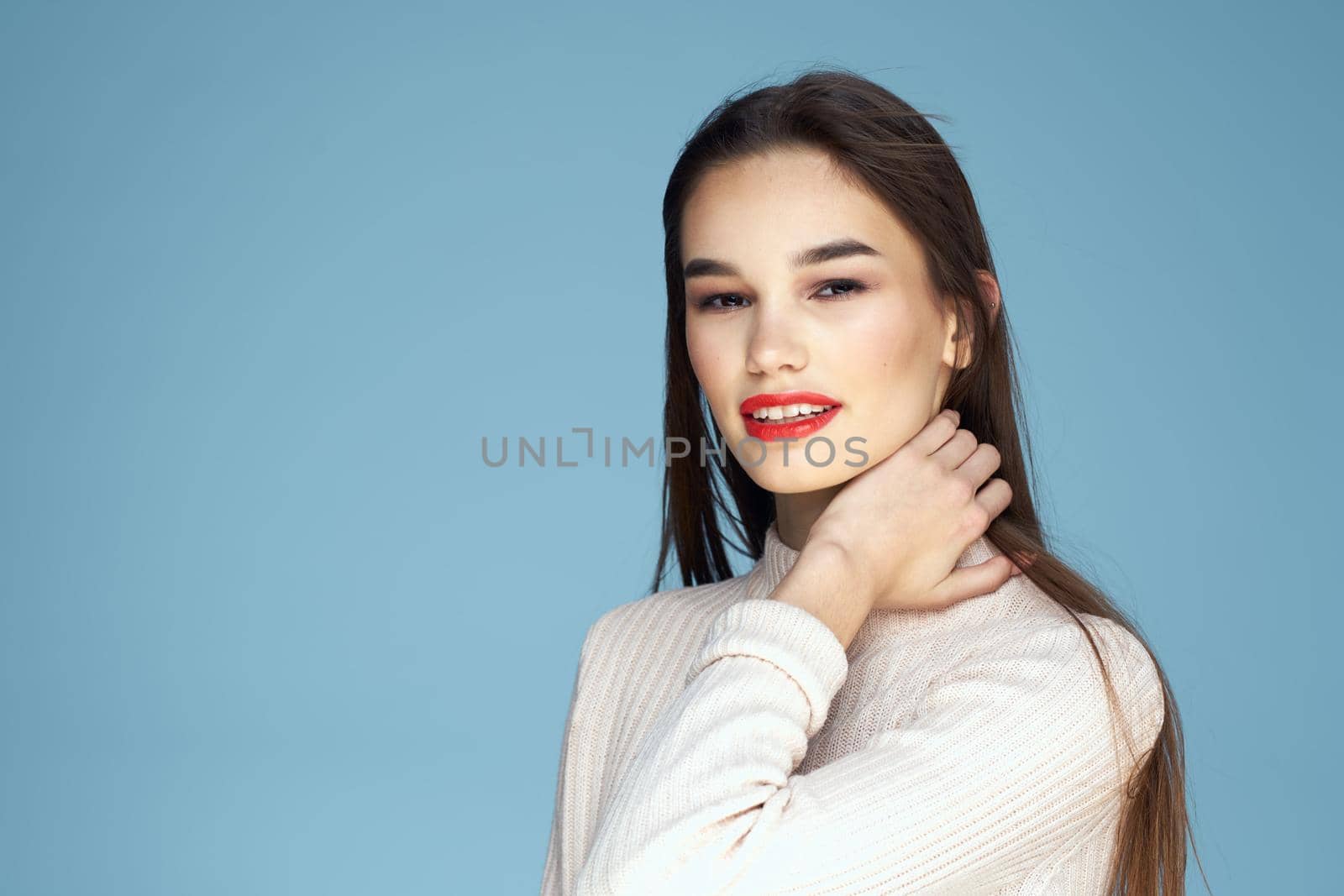 Brunette in white sweater red lips charm cropped view blue background. High quality photo
