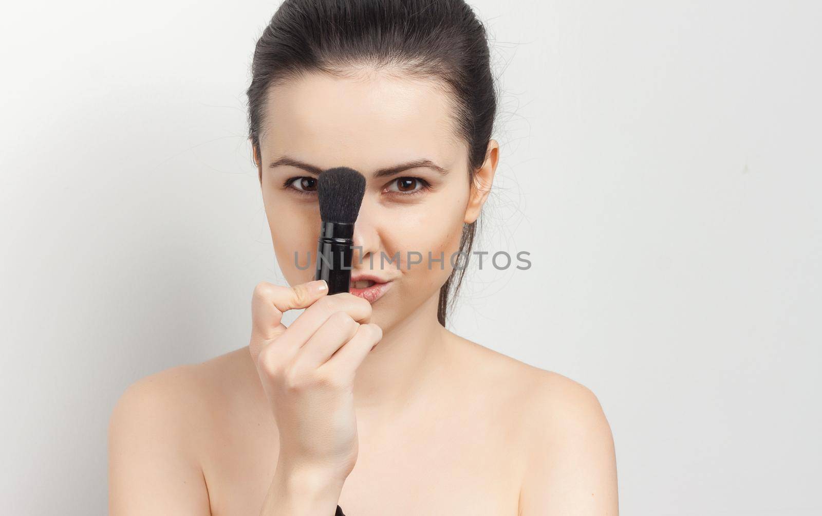 woman with bare shoulders apply brush face mask skin care spa treatments. High quality photo