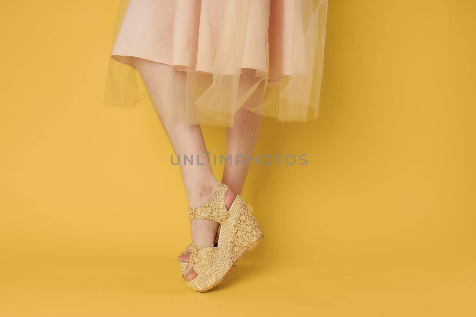 Woman in dress legs shoes attractive look yellow background fashion by SHOTPRIME