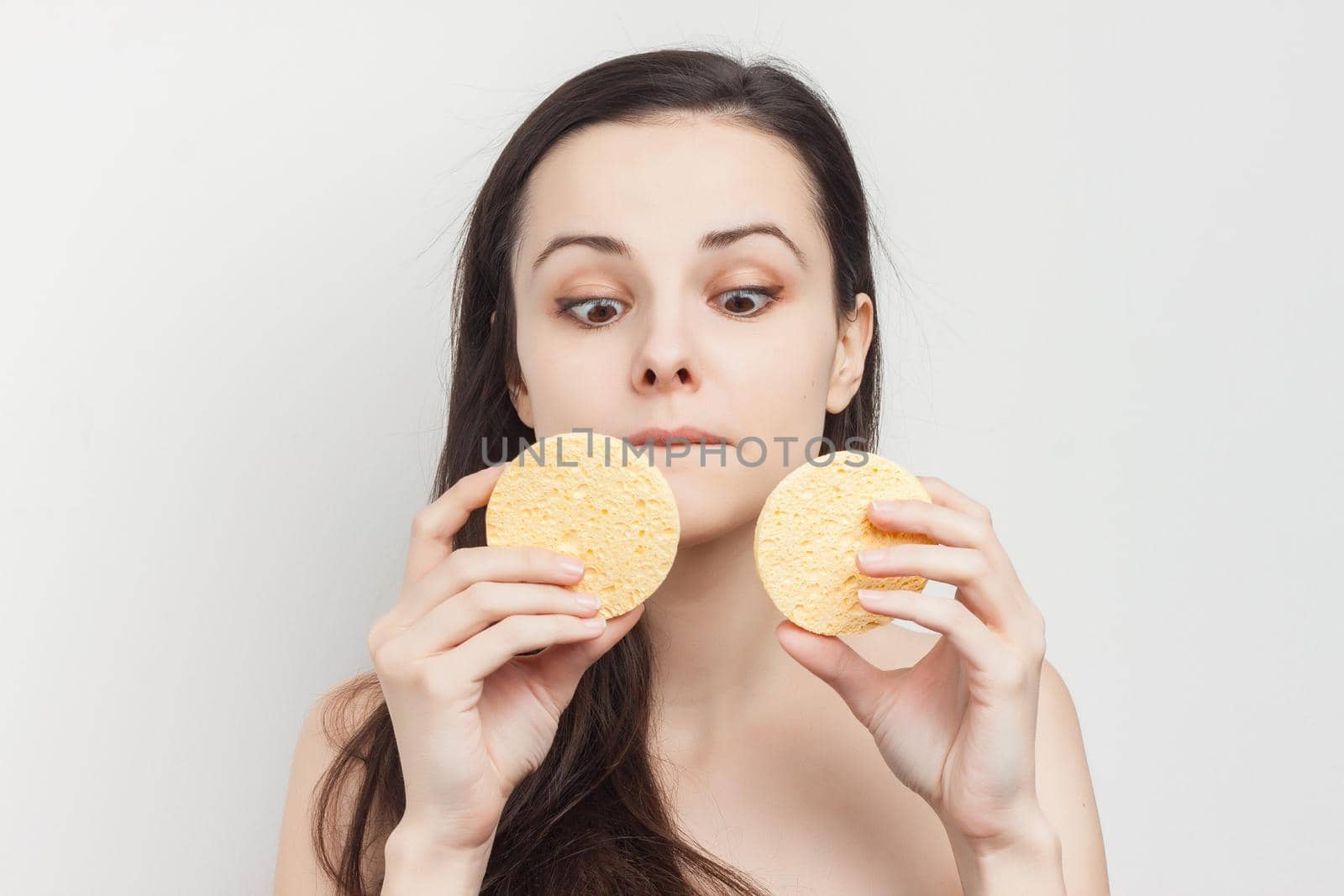 pretty brunette with bare shoulders sponge in hand grooming cropped view. High quality photo