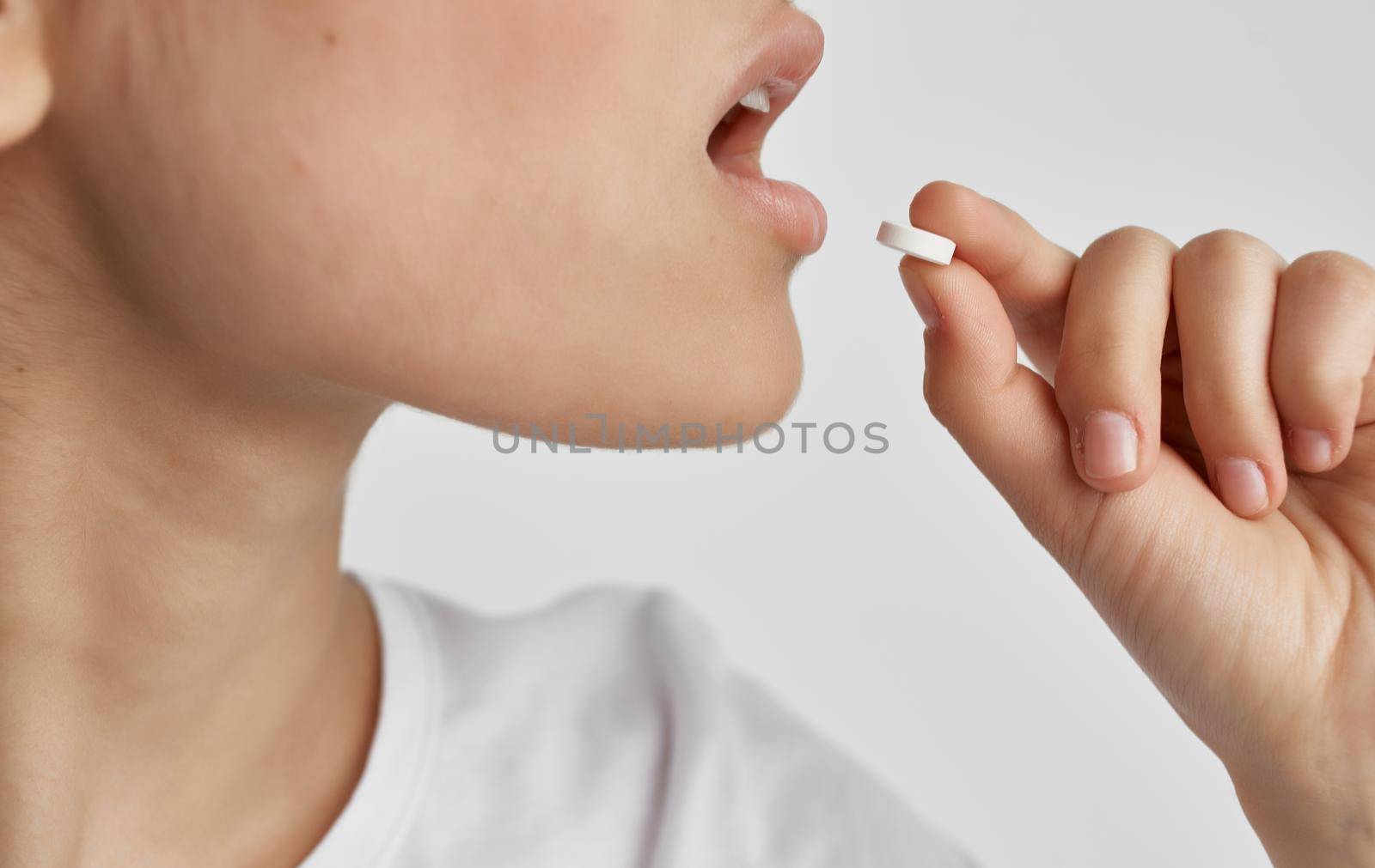 woman taking pills health problems cold light background. High quality photo
