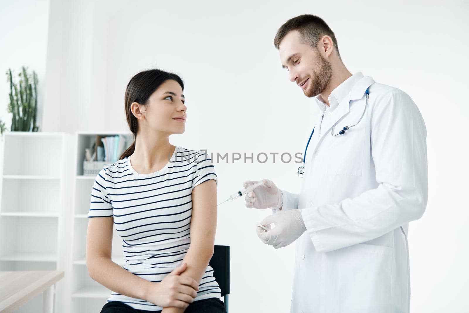male doctor in the hospital makes an injection in the patient's arm vaccination by SHOTPRIME