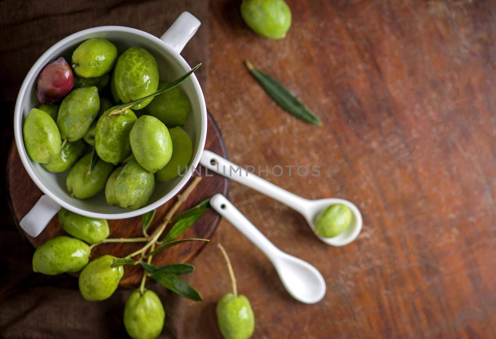 Olive oil and olive branch on black background.