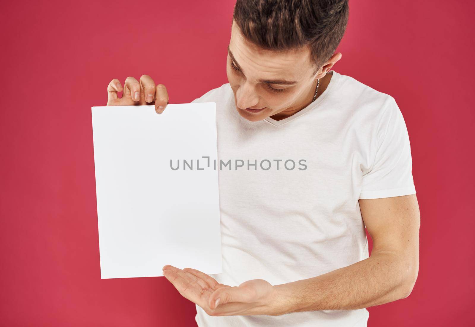 Man with flyer in hand and red background positive gesture model. High quality photo