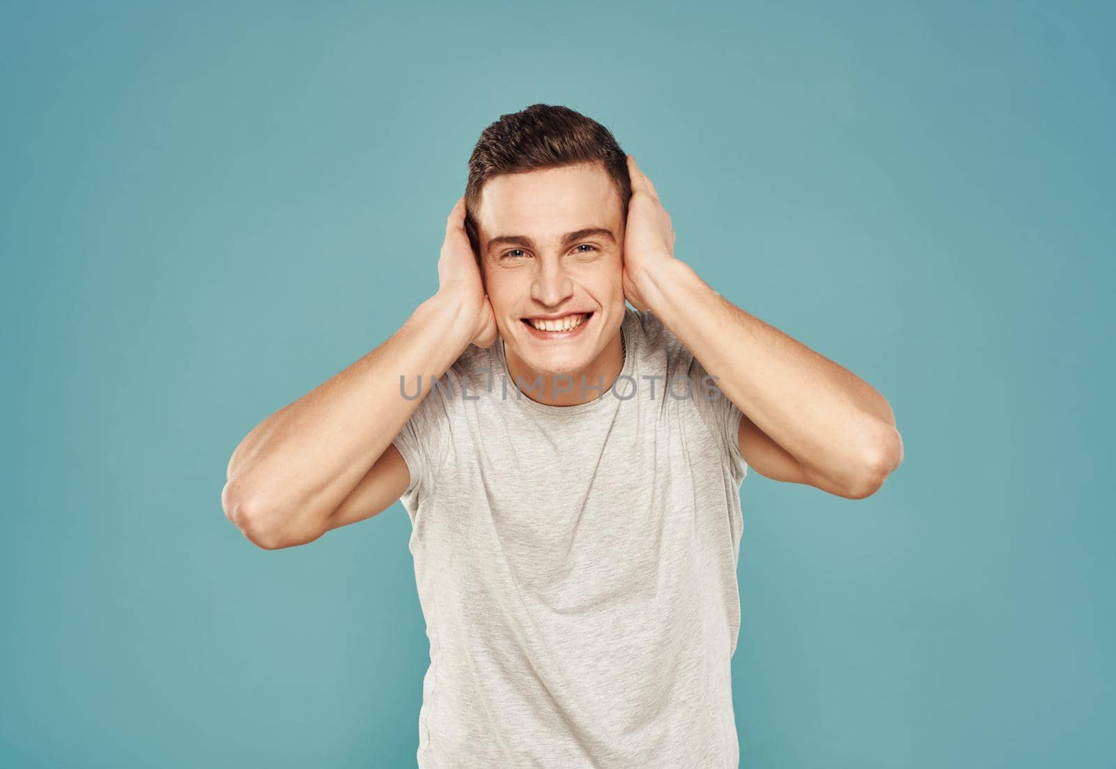 Cheerful man in T-shirt emotions gestures with hands blue background. High quality photo