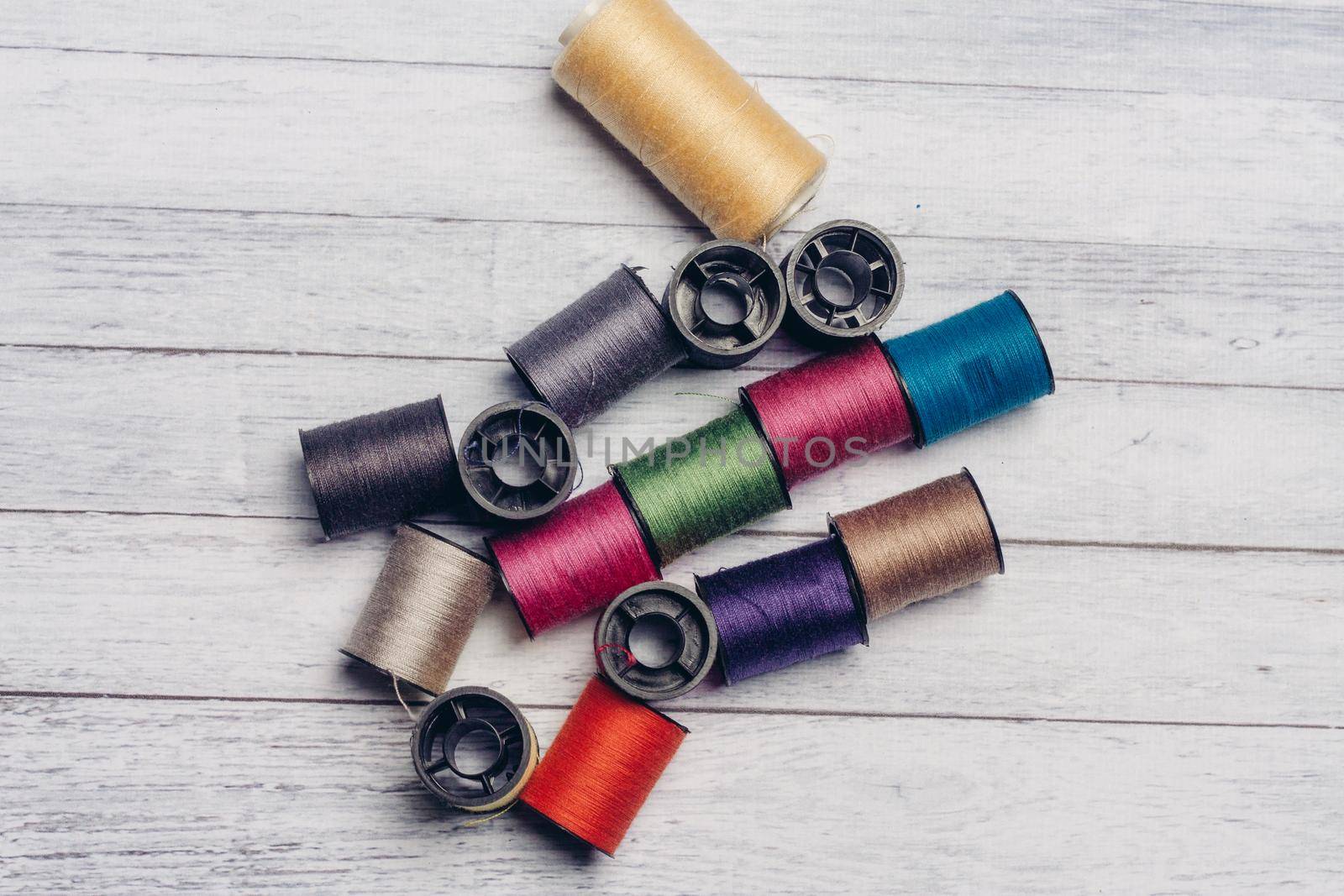 sewing accessories colored threads top view wooden background. High quality photo