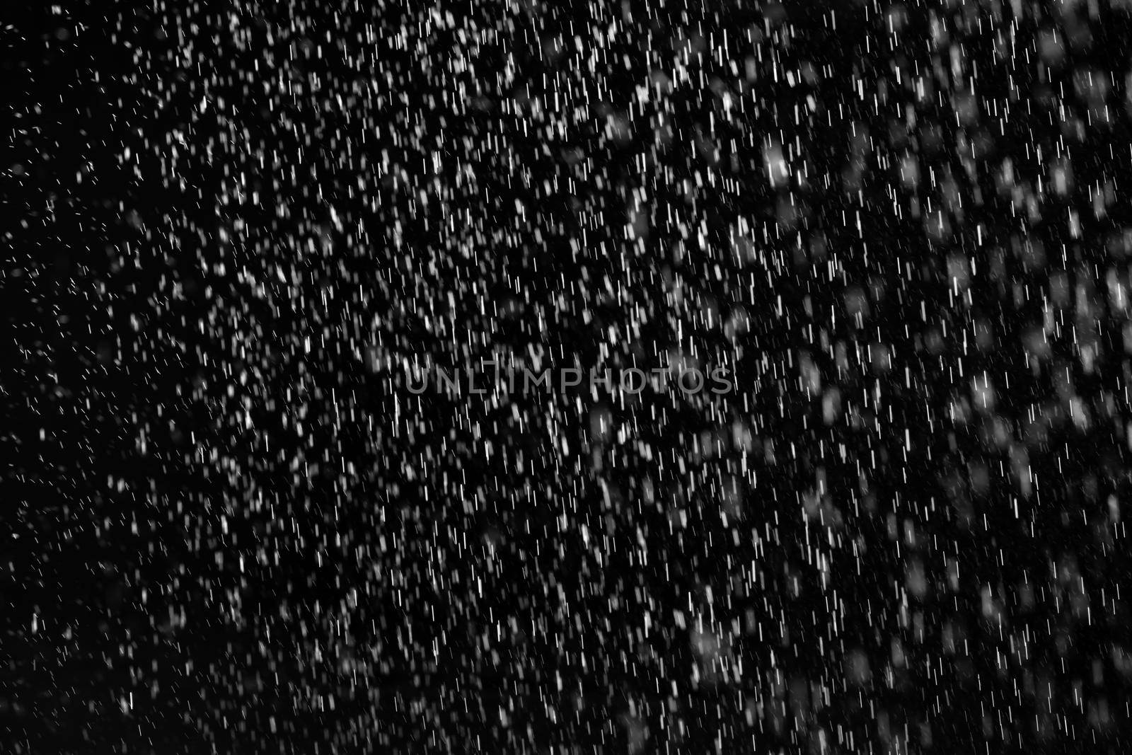 Rain on black. Abstract splashes of water on a black background for screen blending mode and photo retouching.