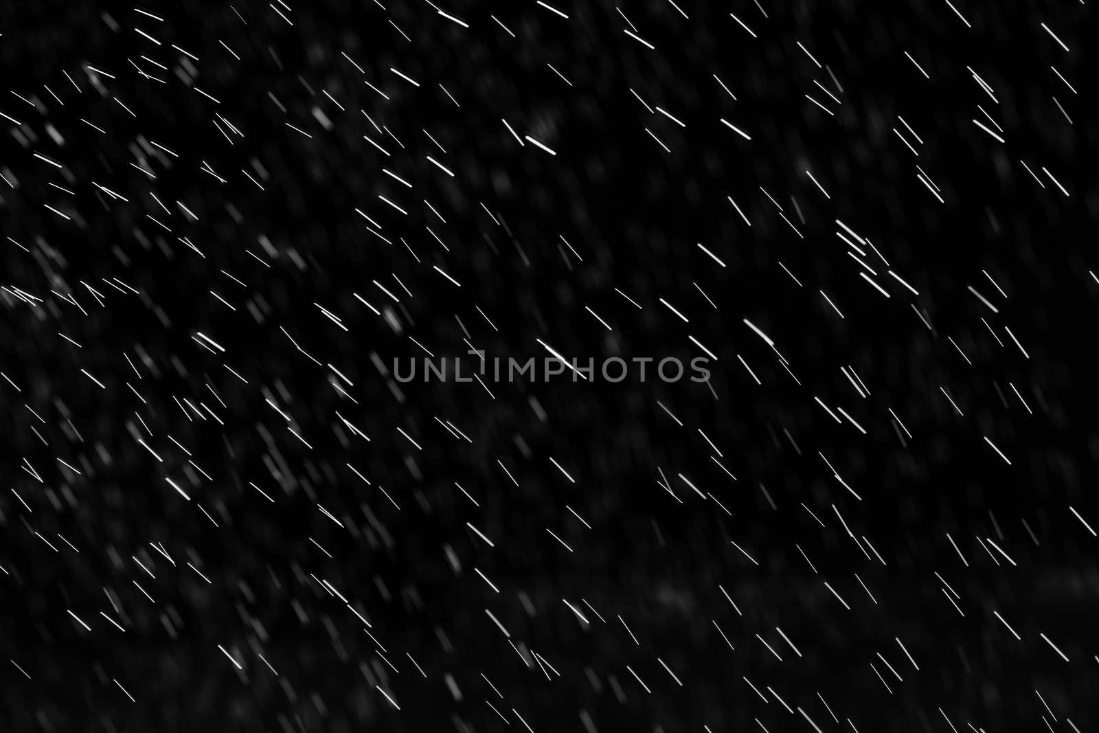 Rain on black. Abstract splashes of water on a black background for screen blending mode and photo retouching.