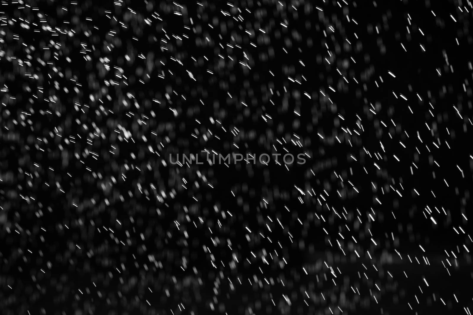 Rain on black. Abstract splashes of water on a black background for screen blending mode and photo retouching.