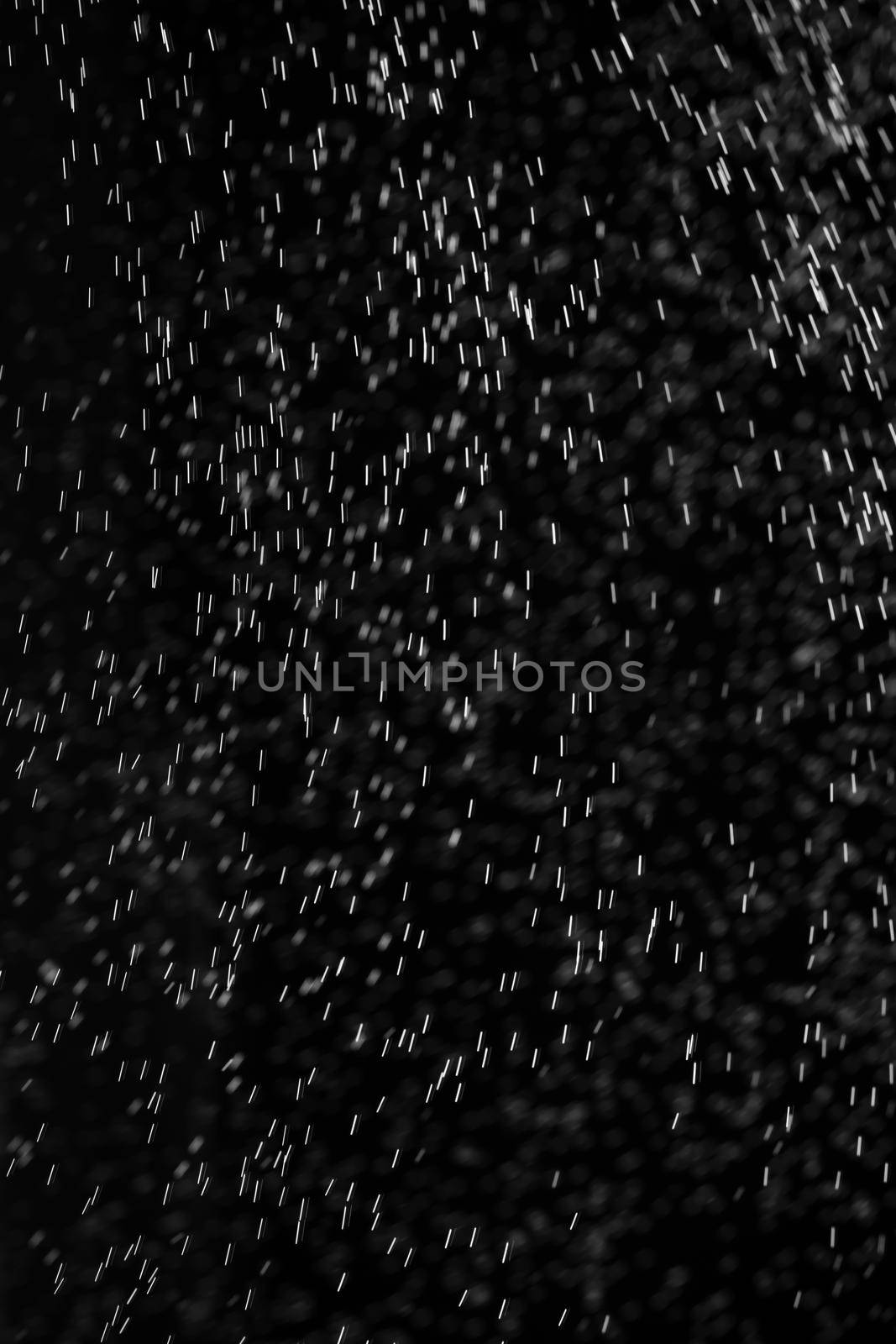 Rain on black. Abstract splashes of water on a black background for screen blending mode and photo retouching.