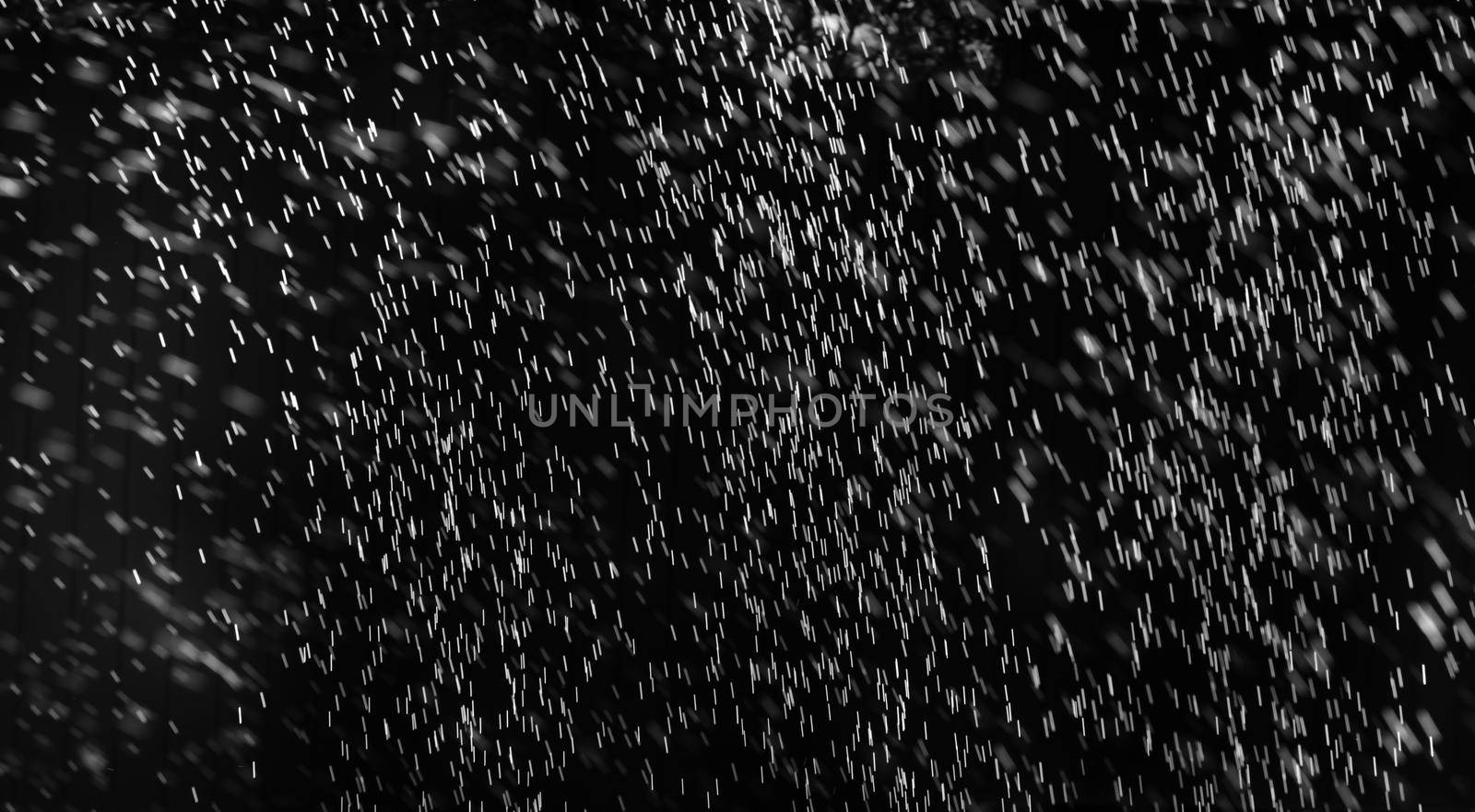 Rain on black. Abstract splashes of water on a black background for screen blending mode and photo retouching.