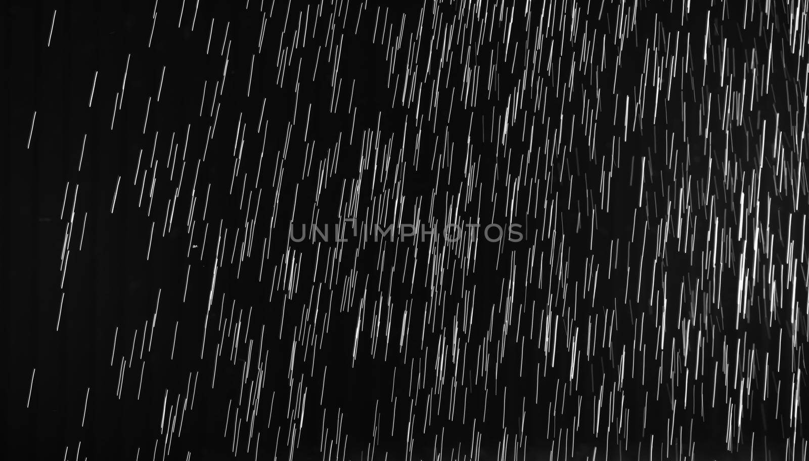 Rain on black. Abstract splashes of water on a black background for screen blending mode and photo retouching.