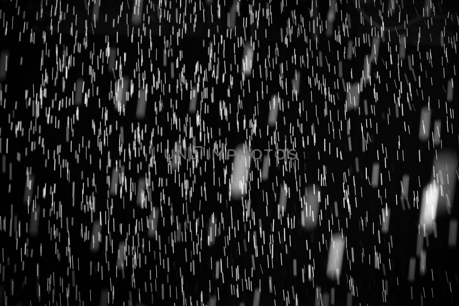 Rain on black. Abstract splashes of water on a black background for screen blending mode and photo retouching.