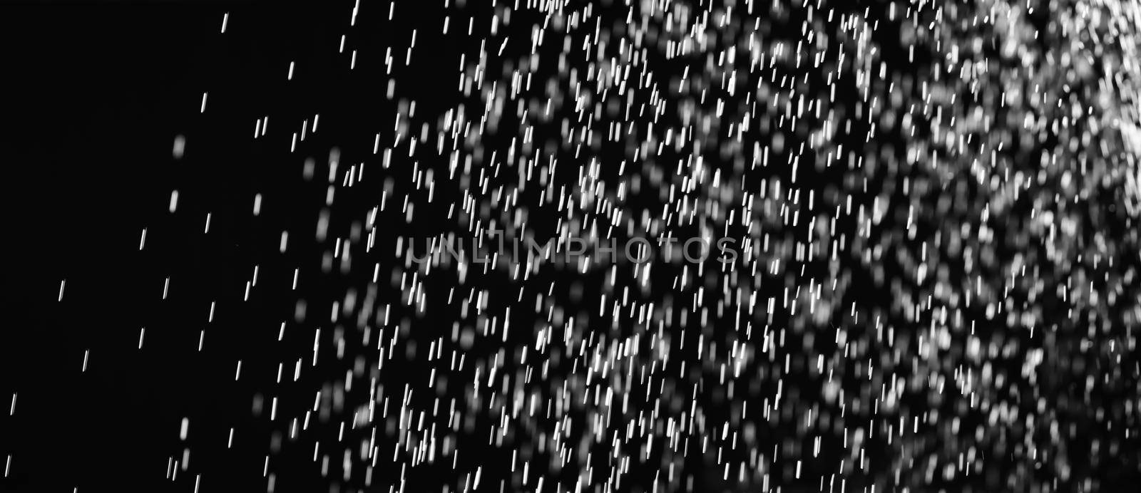 Rain on black. Abstract splashes of water on a black background for screen blending mode and photo retouching.