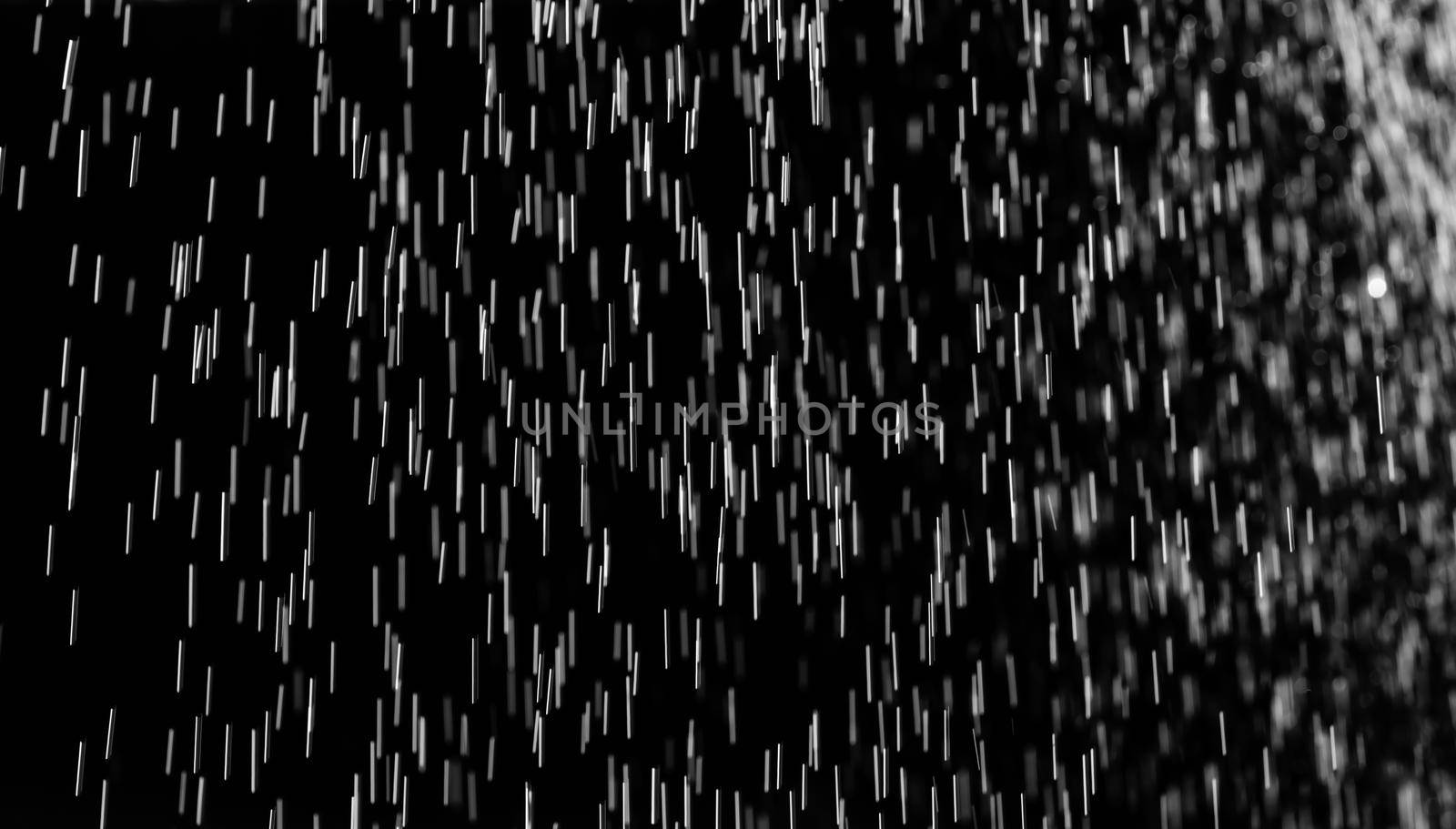 Rain on black. Abstract splashes of water on a black background for screen blending mode and photo retouching.