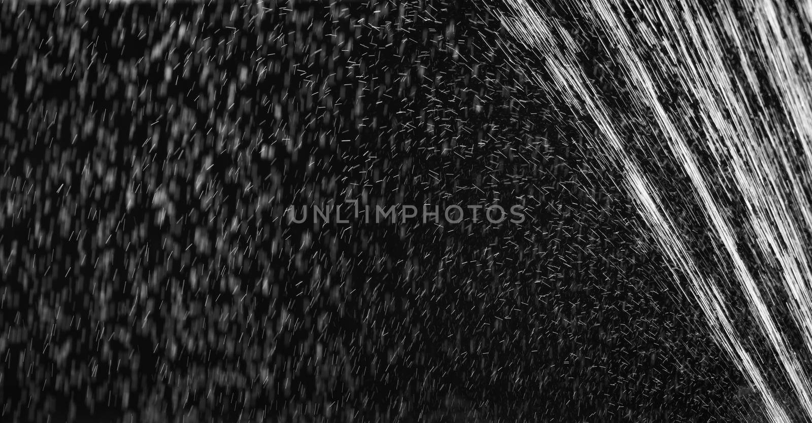 Rain on black. Abstract splashes of water on a black background for screen blending mode and photo retouching.