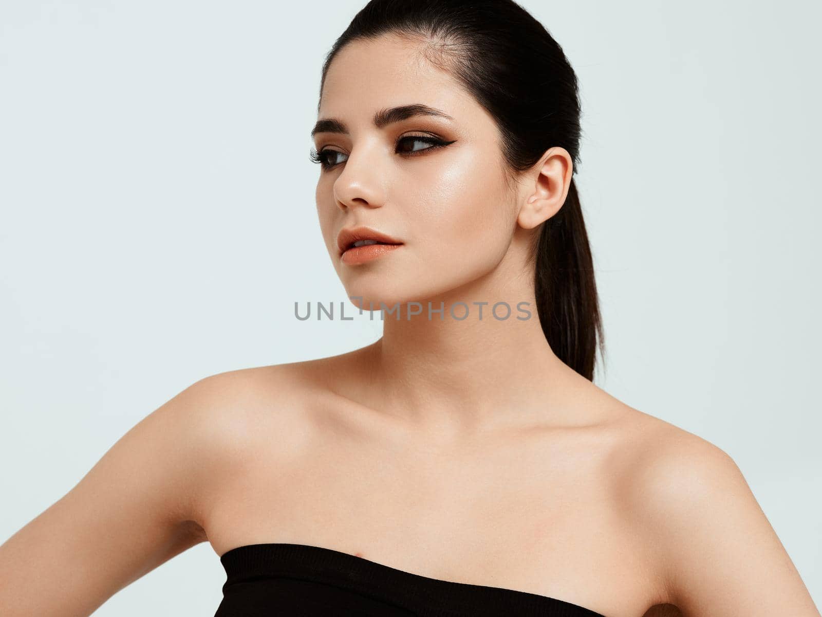 woman approximate casually looks to the side on a light background and shadows on eyelids model. High quality photo